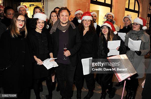 Nicholas Kirkwood poses with The Bistotheque Choir at a Christmas drinks hosted by designer Nicholas Kirkwood to celebrate his partnership with...