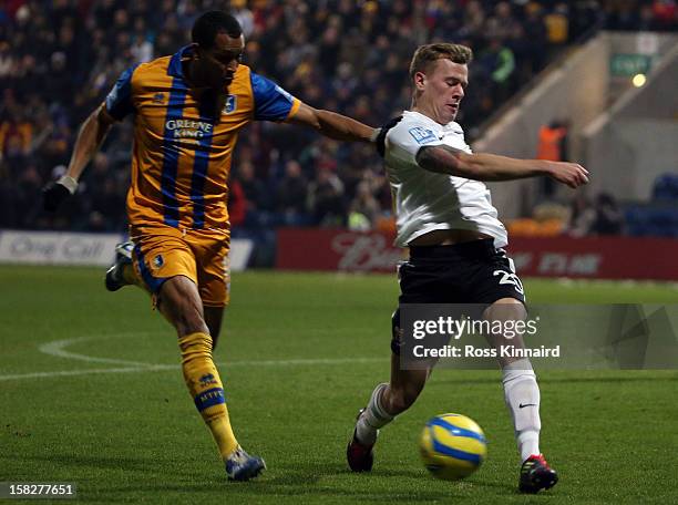 Matt Green of Mansfield is challenged by Tom Miller of Lincoln during the FA Cup with Budweiser Second Round replay match between Mansfield Town and...