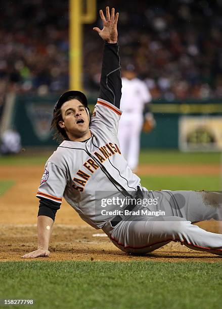 Ryan Theriot of the San Francisco Giants crosses the plate on Marco Scutaro's RBI single in the top of the tenth inning during Game 4 of the 2012...