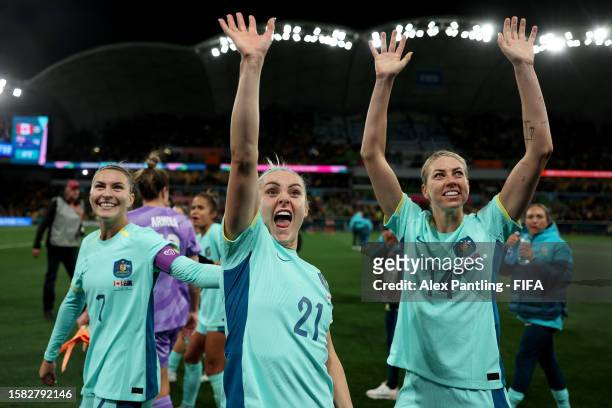 Steph Catley, Ellie Carpenter and Alanna Kennedy of Australia applaud fans after the team's 4-0 victory and qualification for the knockout stage...