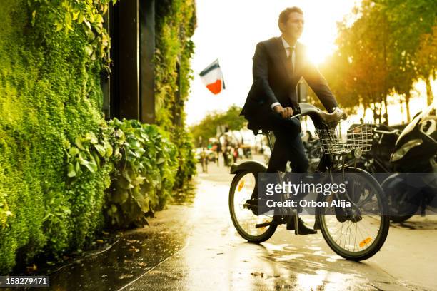 Mann auf Fahrrad vor vertikaler Garten