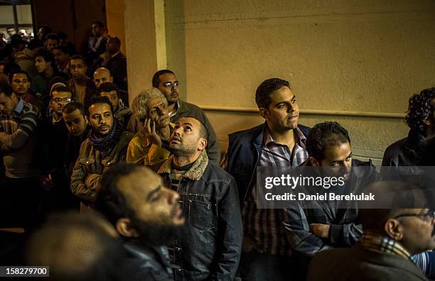 Family and friends of killed journalist El-Hosseiny Abou-Deif wait for his body to be carried out from a morgue on December 12, 2012 in Cairo, Egypt....