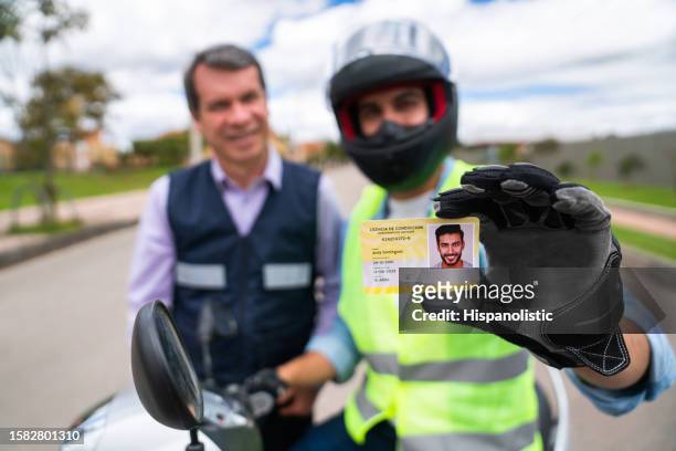 man getting his driver's license after approving his motorcycle driving test - driving licence stock pictures, royalty-free photos & images