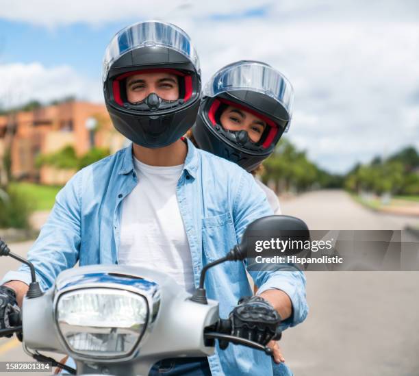 couple heureux qui va faire un tour sur leur moto - gants de sport photos et images de collection