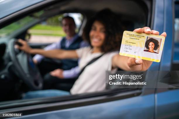 woman passing her driving test and getting her driver's license - driving licence stock pictures, royalty-free photos & images