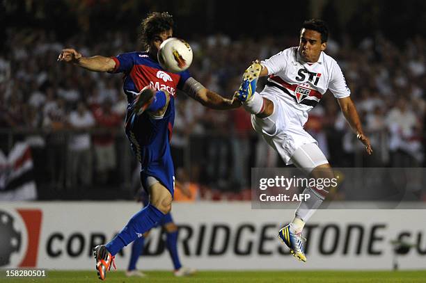 Jadson of Brazil's Sao Paulo vies for the ball with Martin Galmarini of Argentina's Tigre during their Copa Sudamericana football final match at...