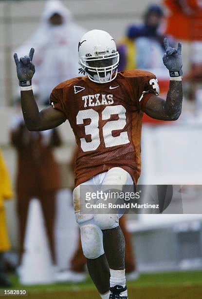 Running back Cedric Benson of the Texas Longhorns gives the "hook em horns" sign after scoring a touchdown during the NCAA football game against the...