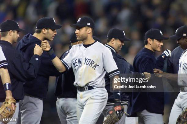 Derek Jeter of the New York Yankees congratulates his team after game two of the American League Championship Series against the Seattle Mariners on...