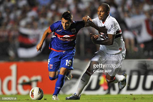 Ruben Botta of Argentina’s Tigre is marked by Joao Felipe of Brazil’s Sao Paulo, during their 2012 Copa Sudamericana final football match held at...