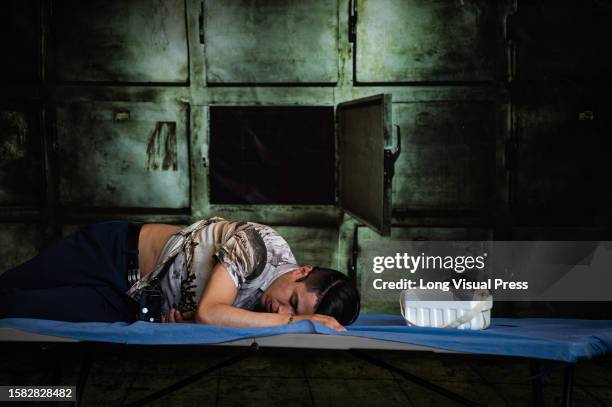 An actor plays a victim of organ trafficking during a play showing the risks and the ways in which people are tricked into illegal human trafficking...