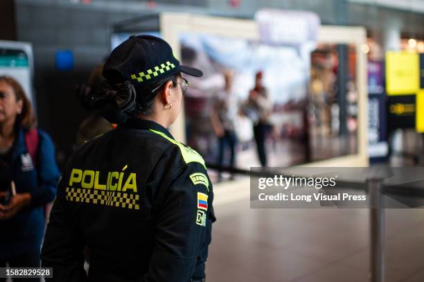 Colombian police officer looks on during a play showing the risks and the ways in which people are tricked into illegal human trafficking networks,...