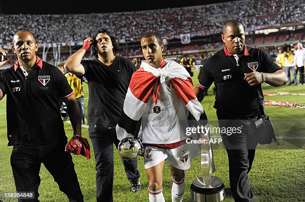 Lucas of Brazil's Sao Paulo leaves with the trophies after the victory of their Copa Sudamericana football final match against Argentine's Tigre at...