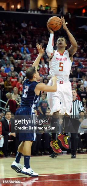 Maryland's Nick Faust shoots over Monmouth's Jesse Steele, left, in the second half at the Comcast Center in College Park, Maryland, on Wednesday,...