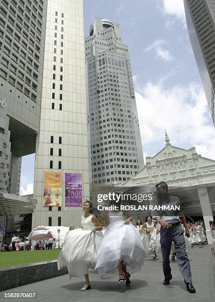 Man looks surprise as dozens of women dressed in bridal costumes dash out of the train station in Singapore's financial district of Raffles Place 03...