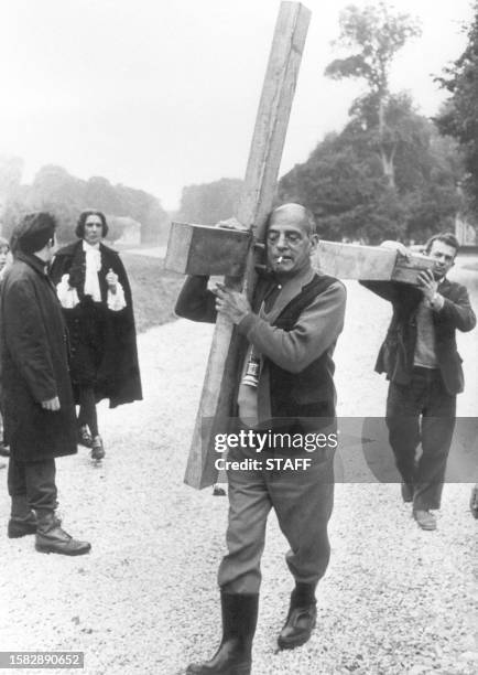 Spanish director Luis Bunuel holds the the Holly Cross to give an idea of the action on the shooting of his 1969 film "The Milky Way". During his...