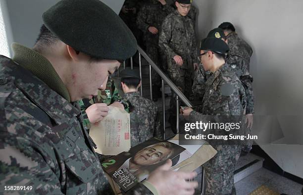 South Korean soldiers queue up to cast their absentee ballots for new President in a polling station on December 13, 2012 in Seoul, South Korea....