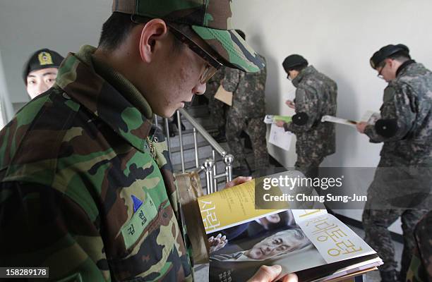 South Korean soldiers queue up to cast their absentee ballots for new President in a polling station on December 13, 2012 in Seoul, South Korea....