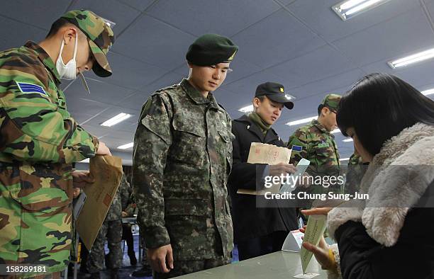 South Korean soldiers queue up to cast their absentee ballots for new President in a polling station on December 13, 2012 in Seoul, South Korea....