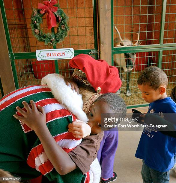 Roberta Smith gets hugs from Mershawn Foster after a tour of the Double R Reindeer Ranch in Midlothian, Texas, on December 4, 2012.