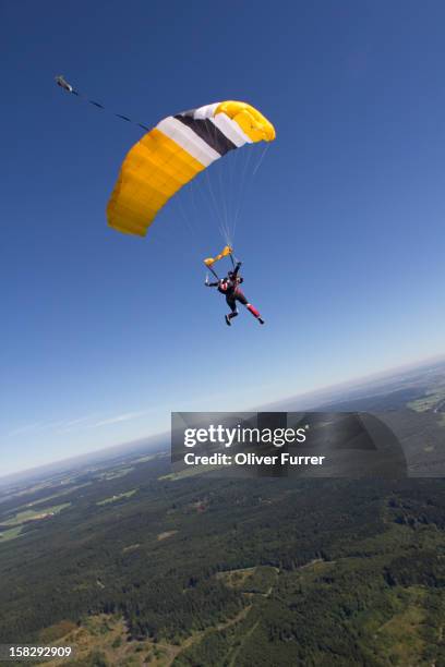 parachutist looking out for a safe landing area - fallschirm stock-fotos und bilder