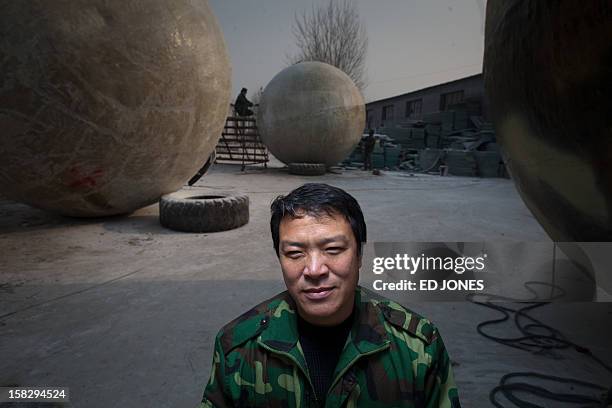 China-society-offbeat-apocalypse,FOCUS by Tom Hancock This photo taken on December 11, 2012 shows farmer Liu Qiyuan posing with survival pods that he...