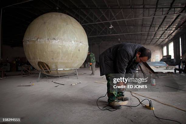 China-society-offbeat-apocalypse,FOCUS by Tom Hancock This photo taken on December 11, 2012 shows a worker constructing a survival pod dubbed 'Noah's...