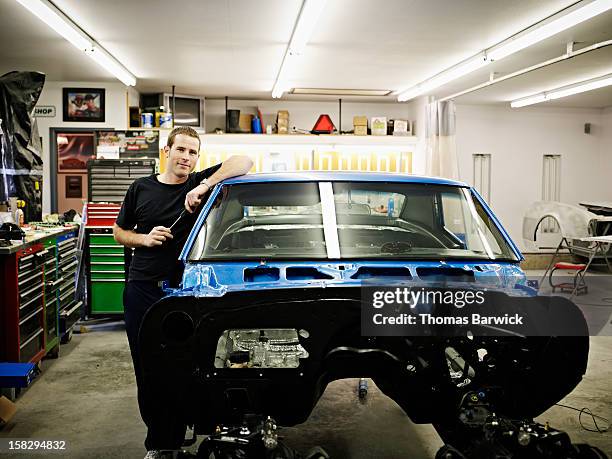 mechanic in garage with car being restored - restoration style photos et images de collection
