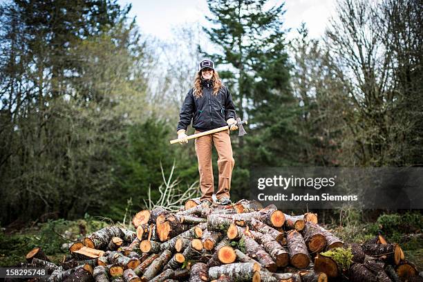 a woman cutting fire wood. - brandhout stockfoto's en -beelden