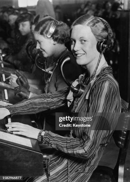 British telephone operator Elsie Barringer, wearing a hands-free headset, at the Holborn Exchange, London, England, 5th November 1932. Barringer has...