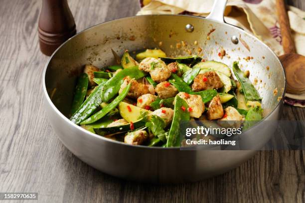 fried chicken, courgettes, and snow pea - pea pod stock pictures, royalty-free photos & images