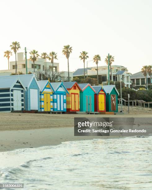 a ground level view of the brighton beach huts and beach in melbourne. - brighton beach melbourne stock pictures, royalty-free photos & images