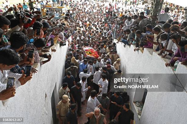 People carry the body of late revolutionary folk singer Balladeer Gaddar during his funeral procession at the Lal Bahadur Stadium in Hyderabad on...