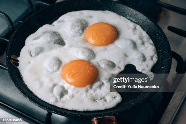 frying egg in a cooking pan in the domestic kitchen. - sunny side up stock pictures, royalty-free photos & images