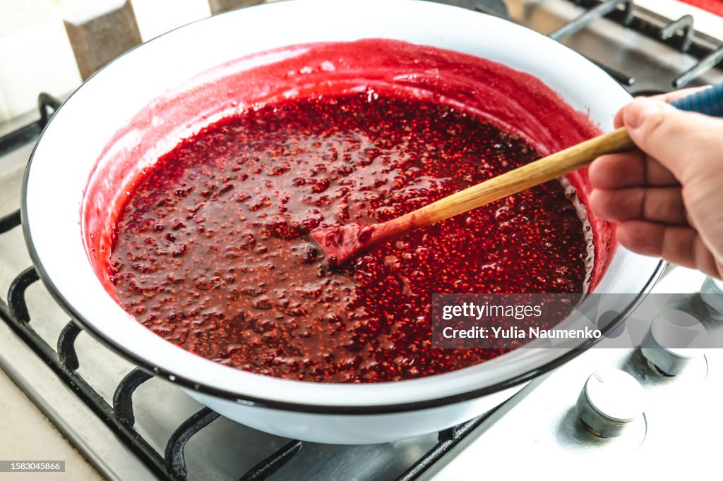 Cooking organic raspberry jam in the kitchen.