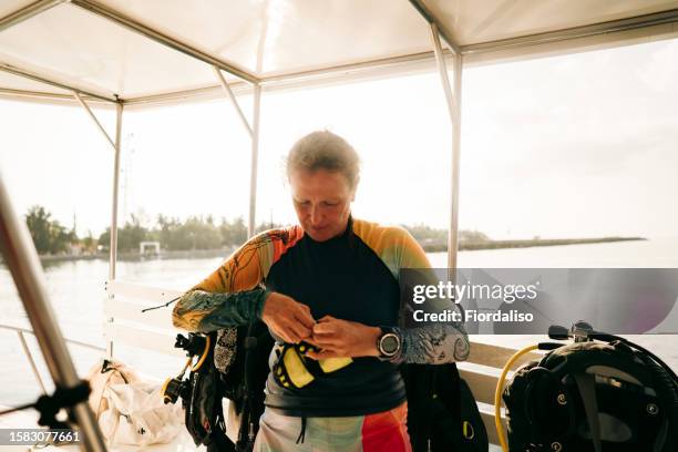 red-haired woman in diving clothes preparing to dive - diving to the ground stock pictures, royalty-free photos & images