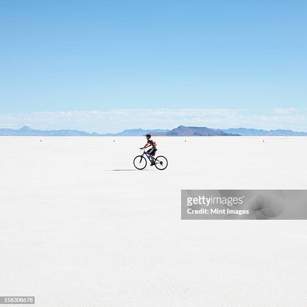 boy riding bike on salt flats, during speed week - bonneville salt flats stock pictures, royalty-free photos & images