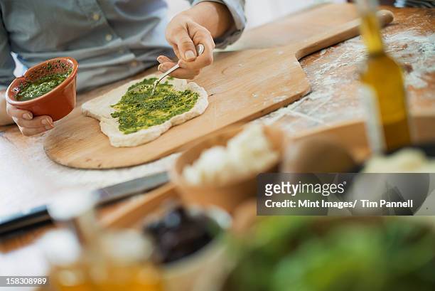 a person making a wrap with fresh ingredients and green salsa. - shandaken stock pictures, royalty-free photos & images