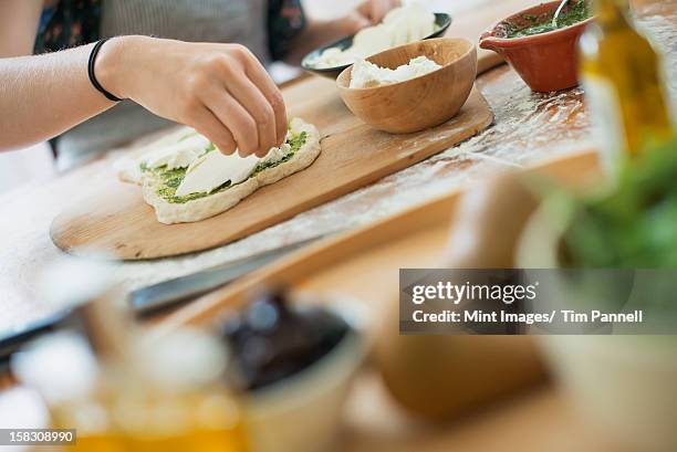 a person making a wrap with fresh ingredients and green salsa. - shandaken stock pictures, royalty-free photos & images