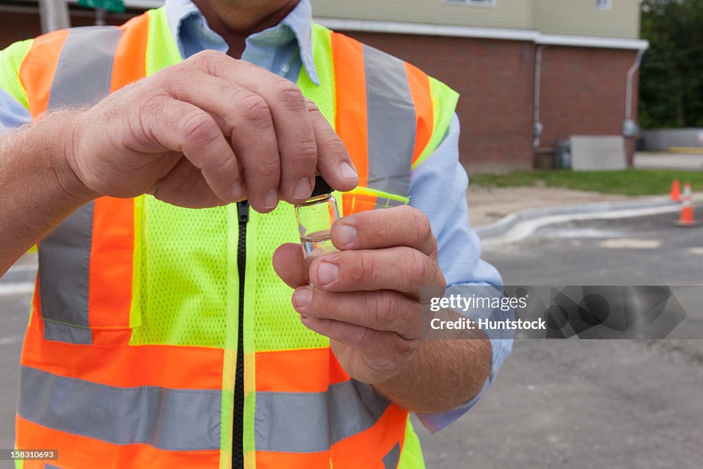 Engineer with a water sample from a street hydrant