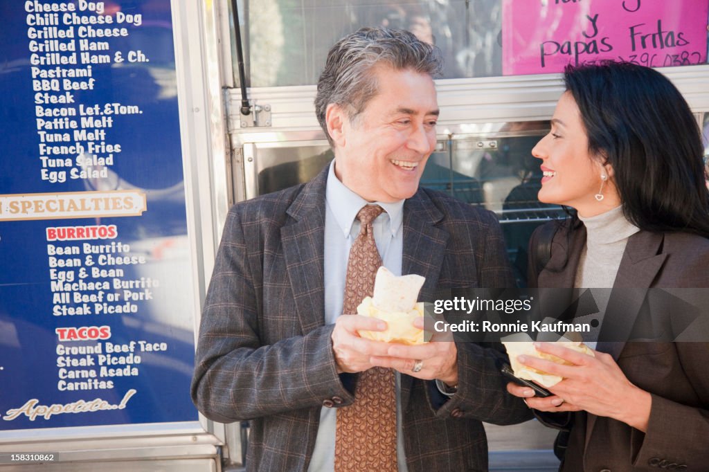 Hispanic couple eating lunch outdoors