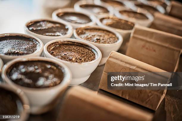 the sampling procedure in a coffee processing shed, where staff make coffee in small pots and sample the taste to test the blend. - coffee processing stock pictures, royalty-free photos & images