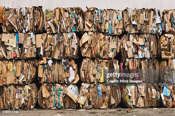recycling facility with bundles of cardboard sorted and tied up for recycling. - recycled material stock pictures, royalty-free photos & images