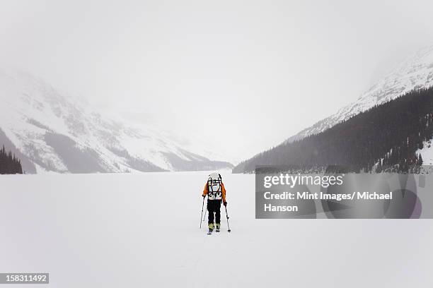 un esquiador de cruzar un lago helado en la wapta traverse, a las montañas - snowfield fotografías e imágenes de stock