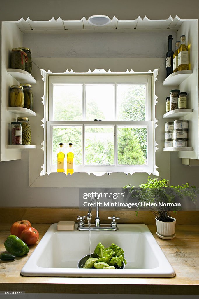 https://media.gettyimages.com/id/158311541/photo/kitchen-window-with-shelves-and-a-traditional-sink-tap-and-running-water-for-washing-vegetables.jpg?s=1024x1024&w=gi&k=20&c=UGBmiQOpvooayU4ILl_pD0yQyEyj2vcFy1qKZrBQpu4=