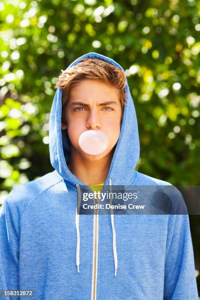 caucasian teenager blowing bubble with gum - hoodie boy stock pictures, royalty-free photos & images