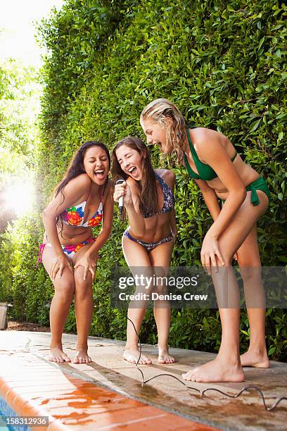 friends with microphone singing near swimming pool - hot latino girl stock pictures, royalty-free photos & images