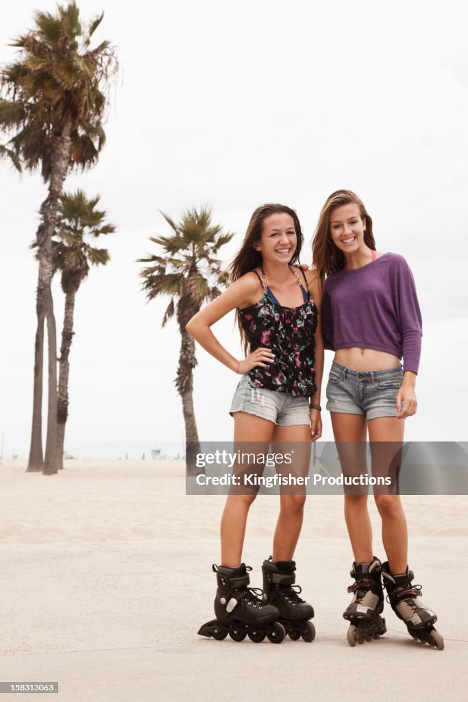 Caucasian teenagers roller blading at beach