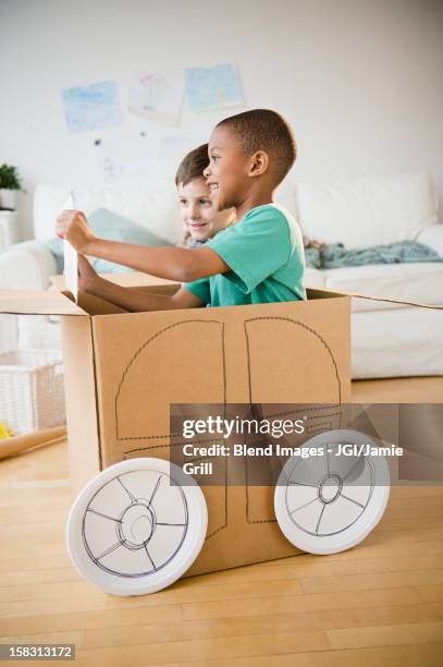 boys playing in a cardboard car together - boy playing with cars stock pictures, royalty-free photos & images