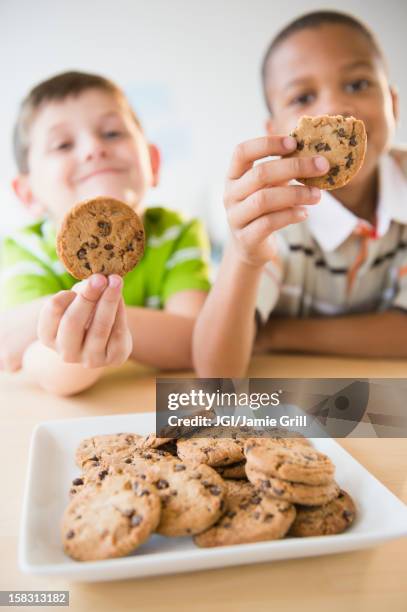 boys eating chocolate chip cookies - kid eating chocolate chip cookie stock pictures, royalty-free photos & images