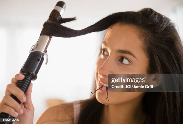 hispanic teenager curing her hair - hair curlers stock-fotos und bilder